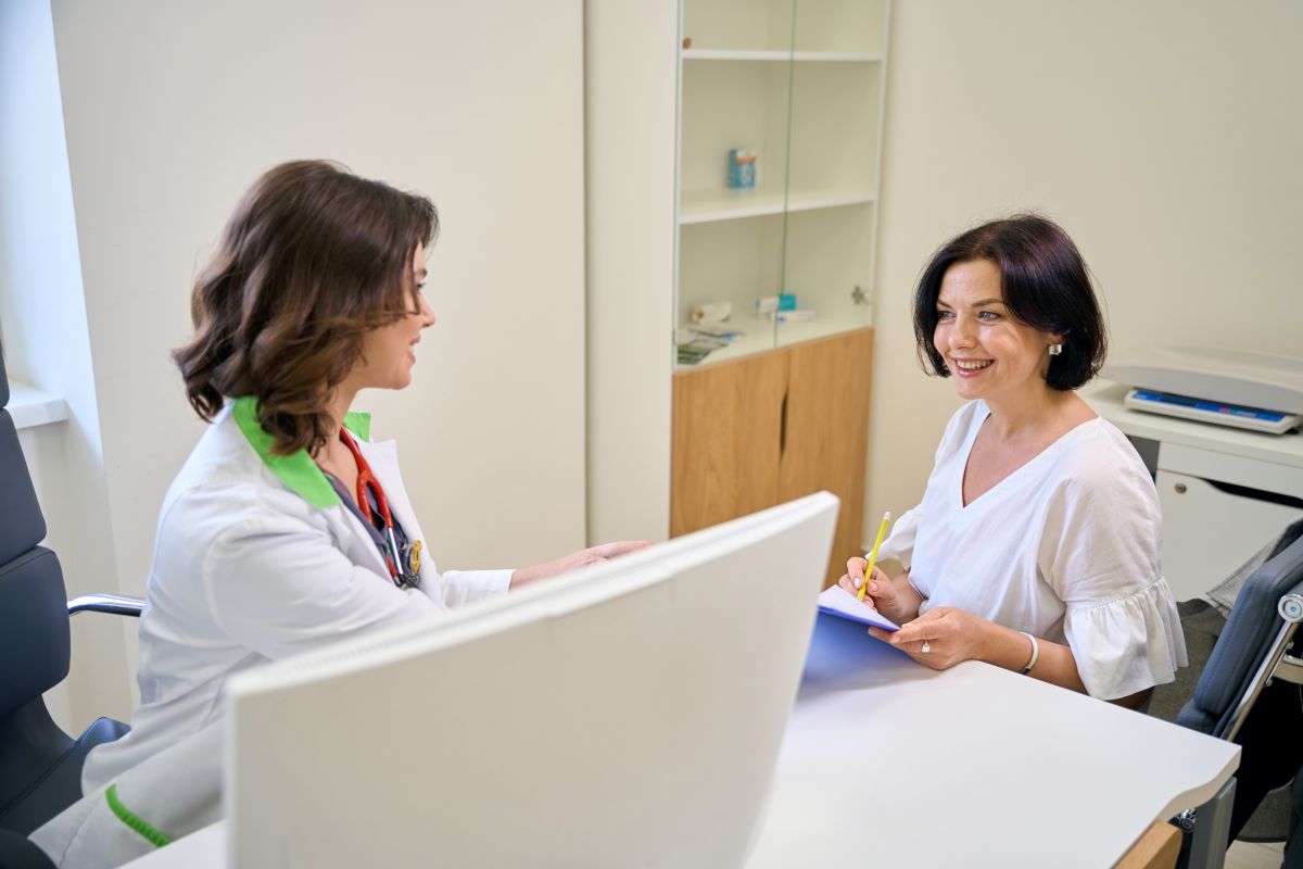 Un doctor și o pacientă discutând tespre noile code de indemnizație pentru concedii medicale