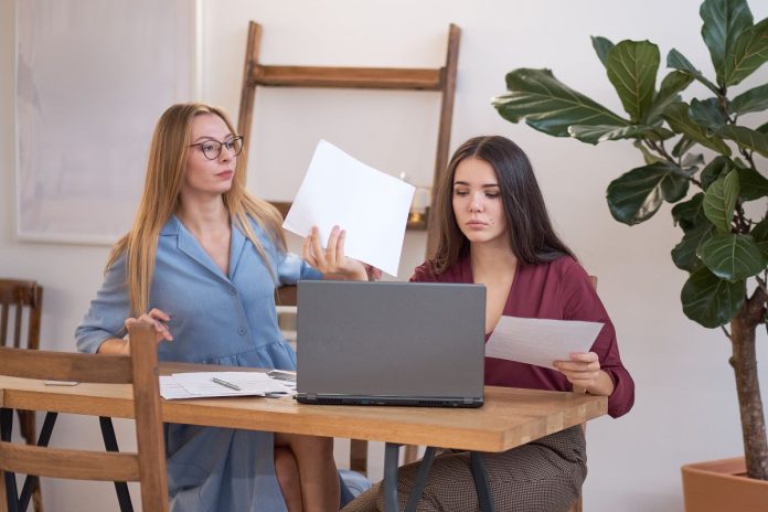 two-women-collaborate-at-a-table-with-laptop-2026-01-09-11-57-10-utc